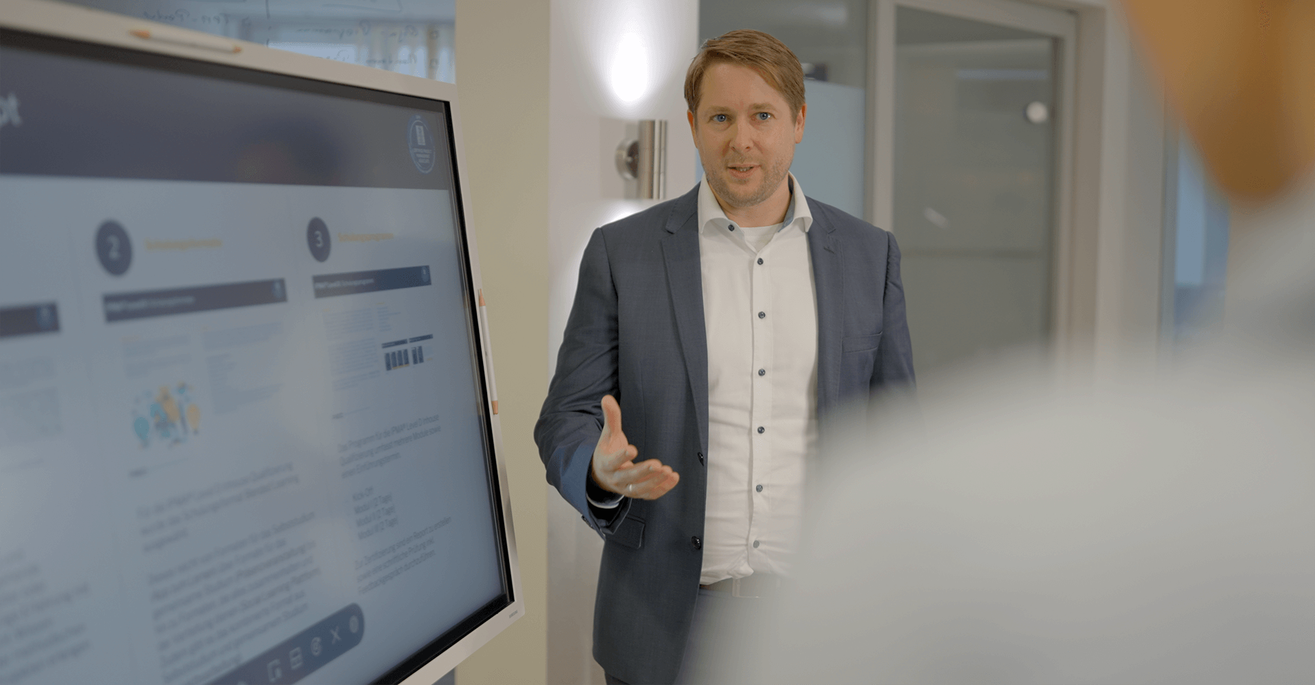 pec-portfolio-prozessmanagement Markus Hegeler stellt einem Mitarbeiter die Vorteile des Prozessmanagements durch die PEC anhand einer Präsentation vor.